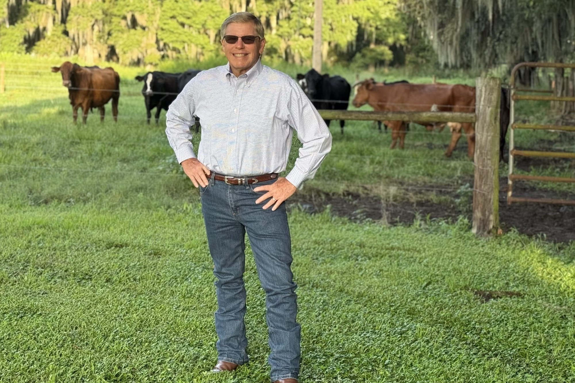 Rick Wilson standing in a pasture with his cattle behind him on the family ranch in Bartow